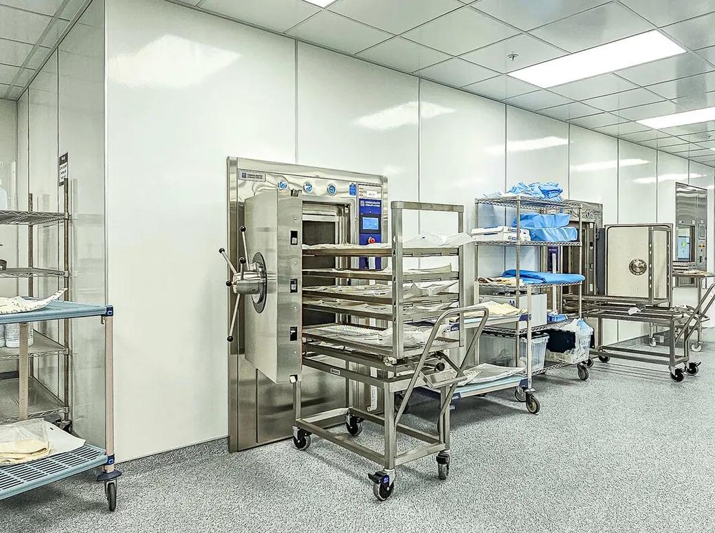 Sterile processing room with a stainless steel autoclave and staging carts