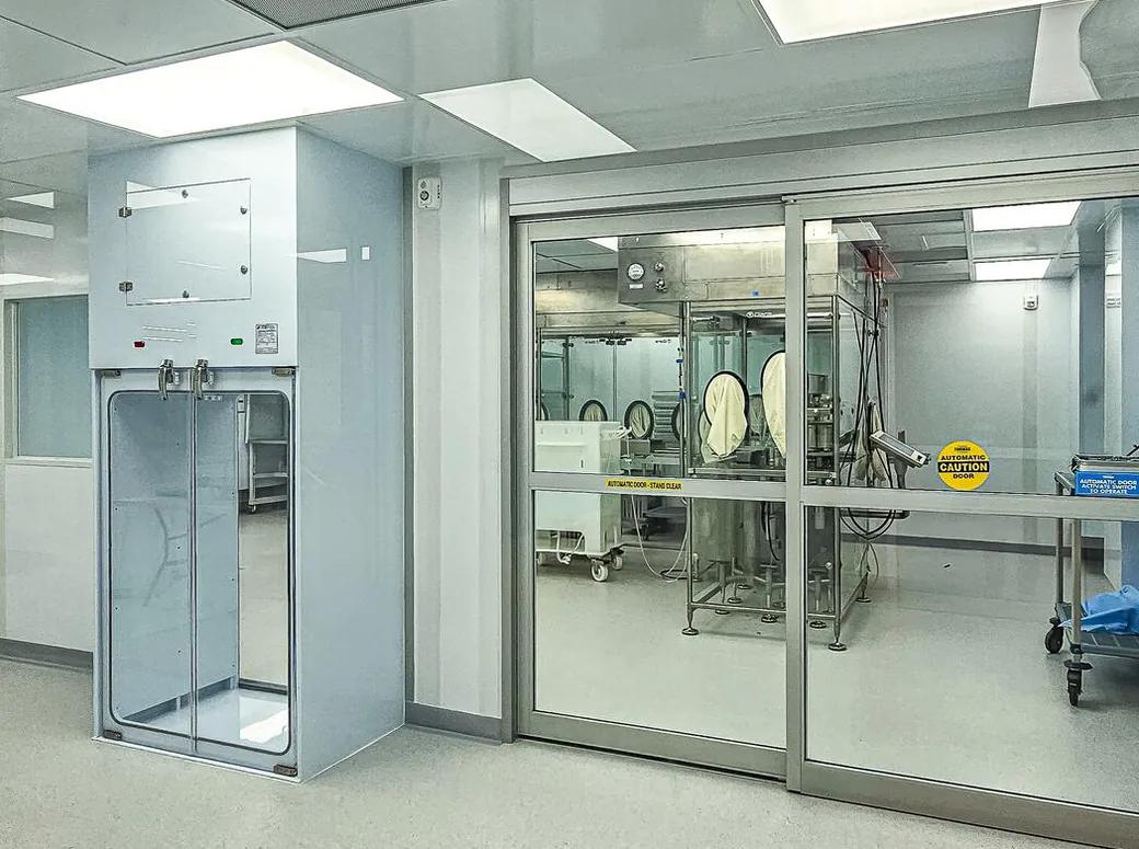 Sterile suite with automatic doors, pass-through chamber, and isolator equipment beyond
