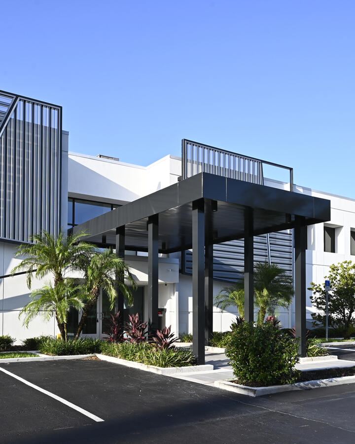 Commercial facility exterior with screened mechanical enclosure and covered entry canopy