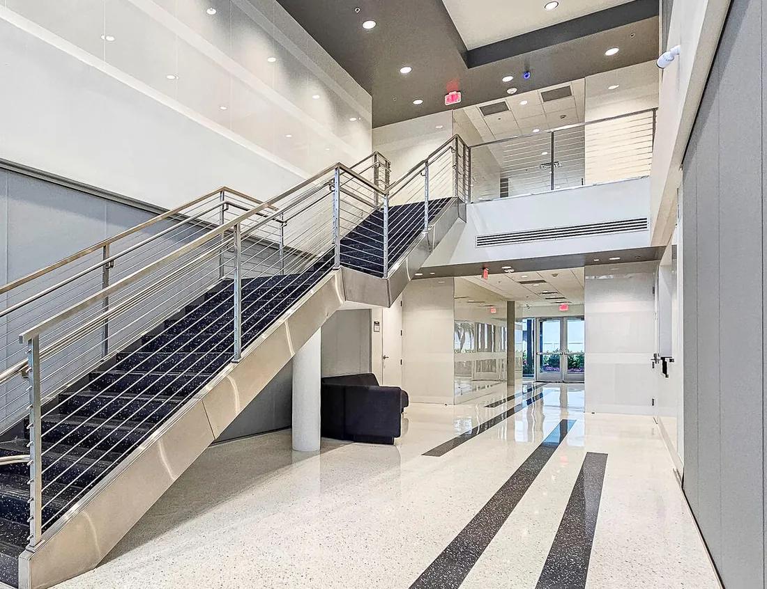 Commercial lobby with terrazzo flooring and an open stainless steel stair
